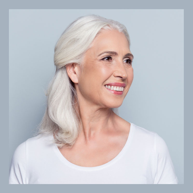 Dojrzała kobieta po zabiegu pielęgnacyjnym twarzy Rejuvi.